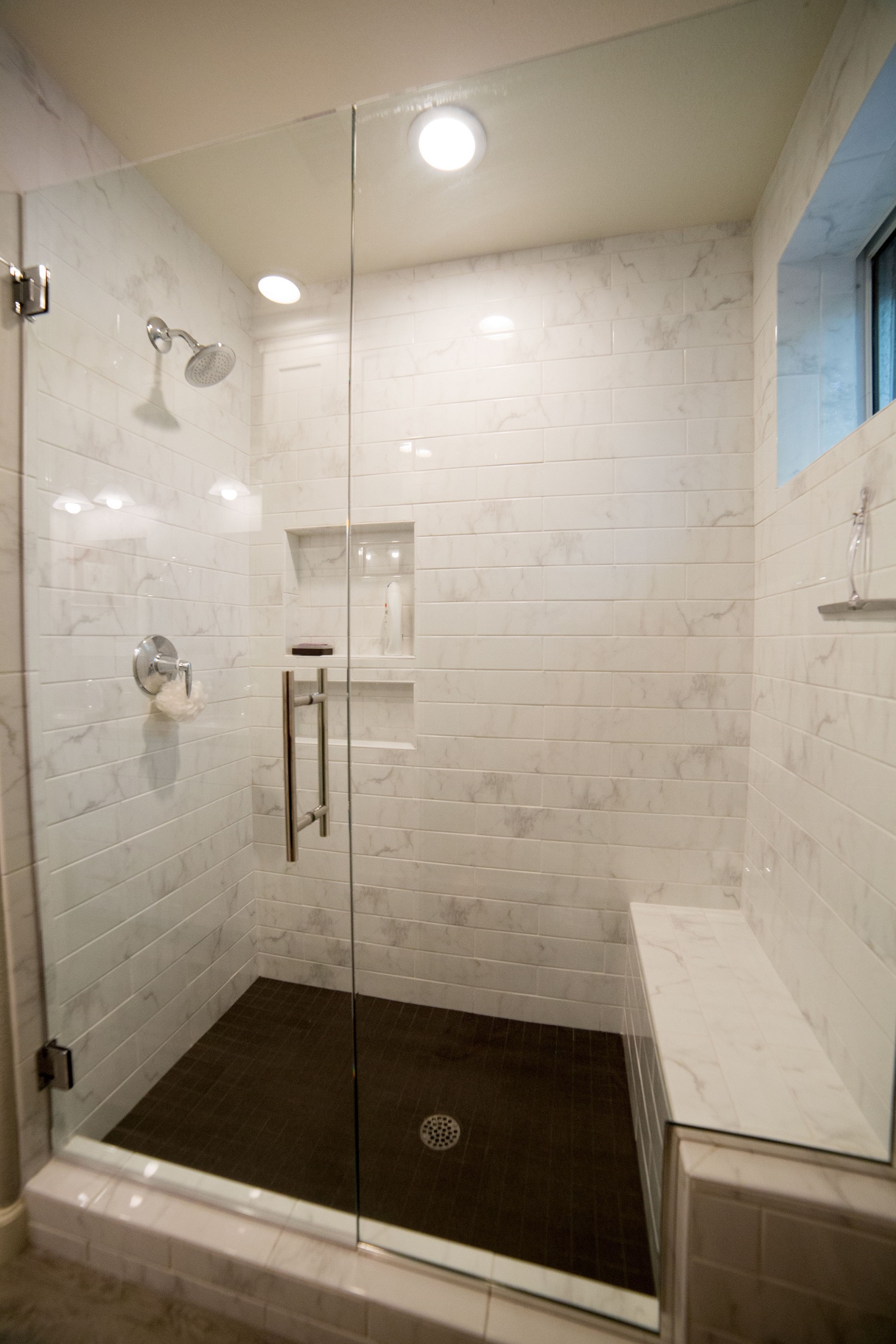 Guest Bathroom remodel in gray and white color palette. Gorgeous walk-in shower features polished porcelain 4x16 tile on the wall and shower seat with 2"x2" tiles on the shower floor. [TWD Project Location: Goodyear, AZ]