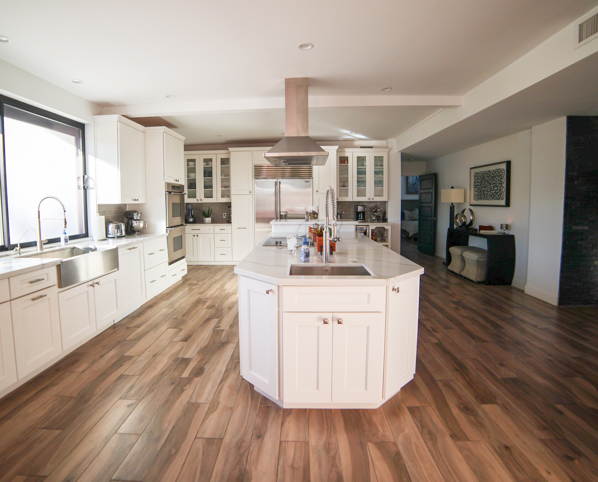 This full home renovation went from a complete gut to completely gorgeous. The kitchen features Wellborn Premier series cabinetry in a Glacier White finish with quartz countertop, gray ceramic tile backsplash, (2) kitchen sinks, stainless steel appliances and hood. [TWD Project Location: Litchfield Park, AZ]