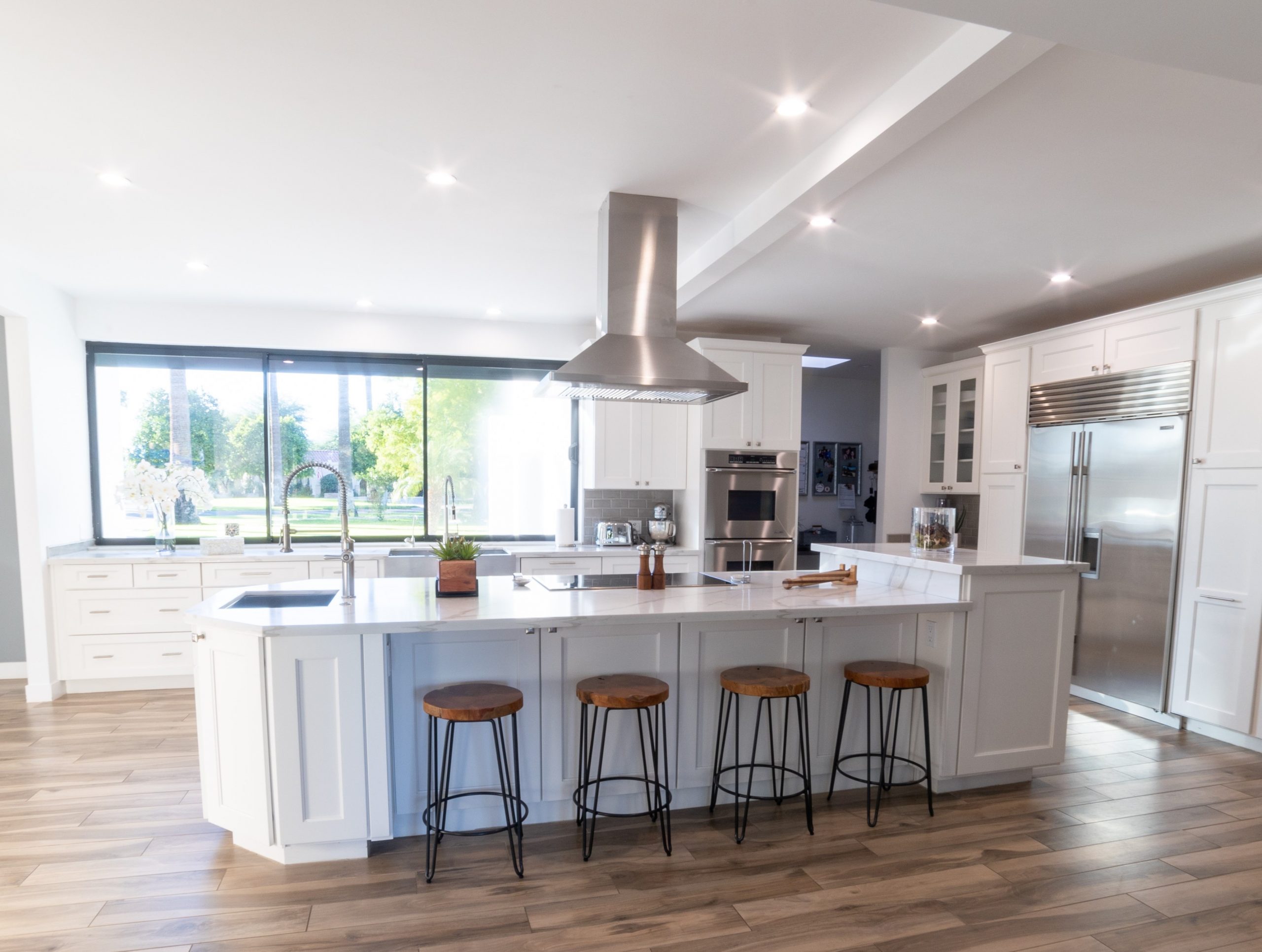 This full home renovation went from a complete gut to completely gorgeous. The kitchen features Wellborn Premier series cabinetry in a Glacier White finish with quartz countertop, gray ceramic tile backsplash, (2) kitchen sinks, stainless steel appliances and hood. [TWD Project Location: Litchfield Park, AZ]