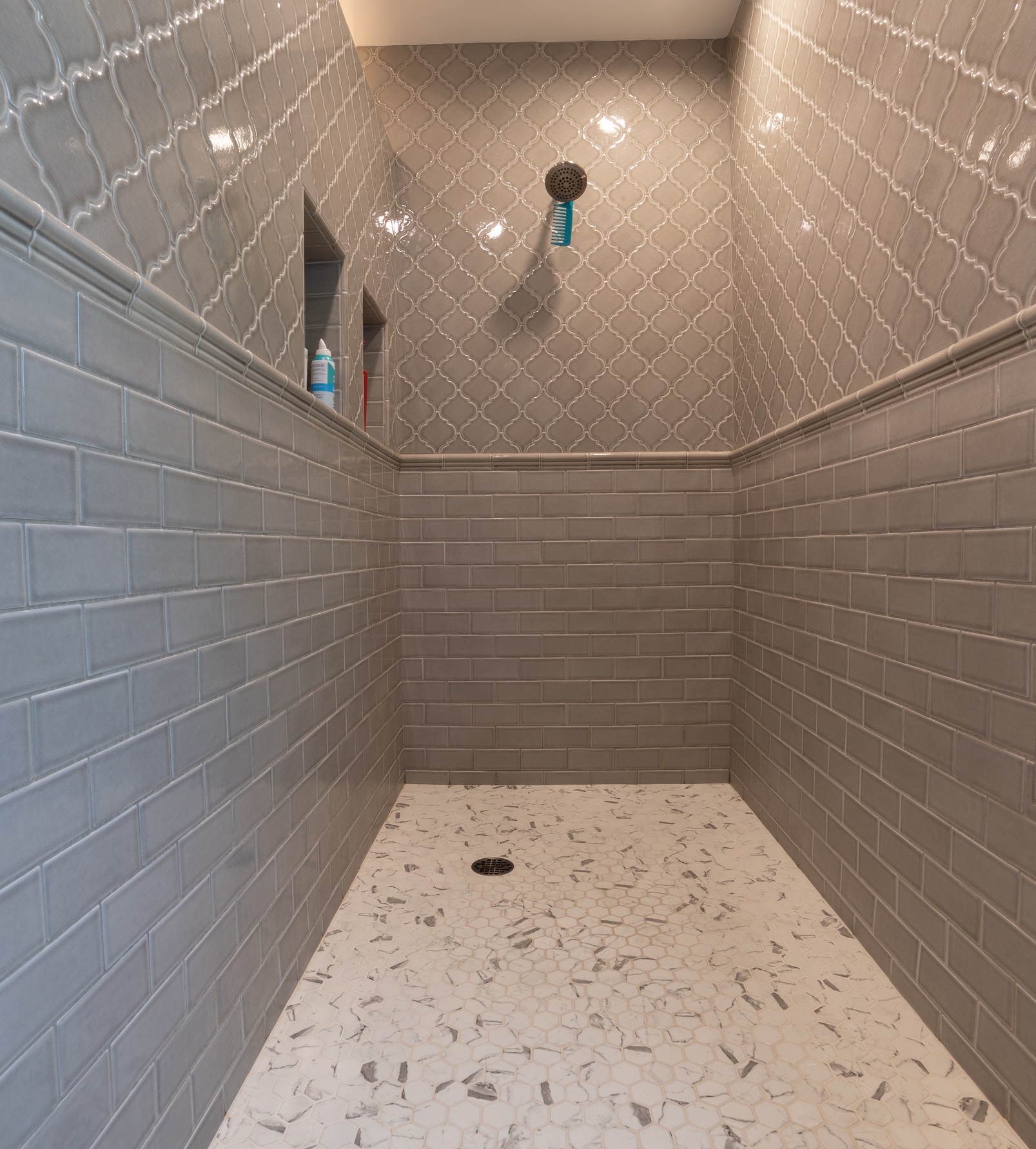 This master suite bathroom includes a spacious walk in shower. The bottom portion of the shower walls include 3" x 6" gray subway tile, while the top portion of the walls is a matching gray tone diamond with White Dots tile and 2" x 2" hexagon tile used on the shower floor. [TWD Project Location: Litchfield Park, AZ]