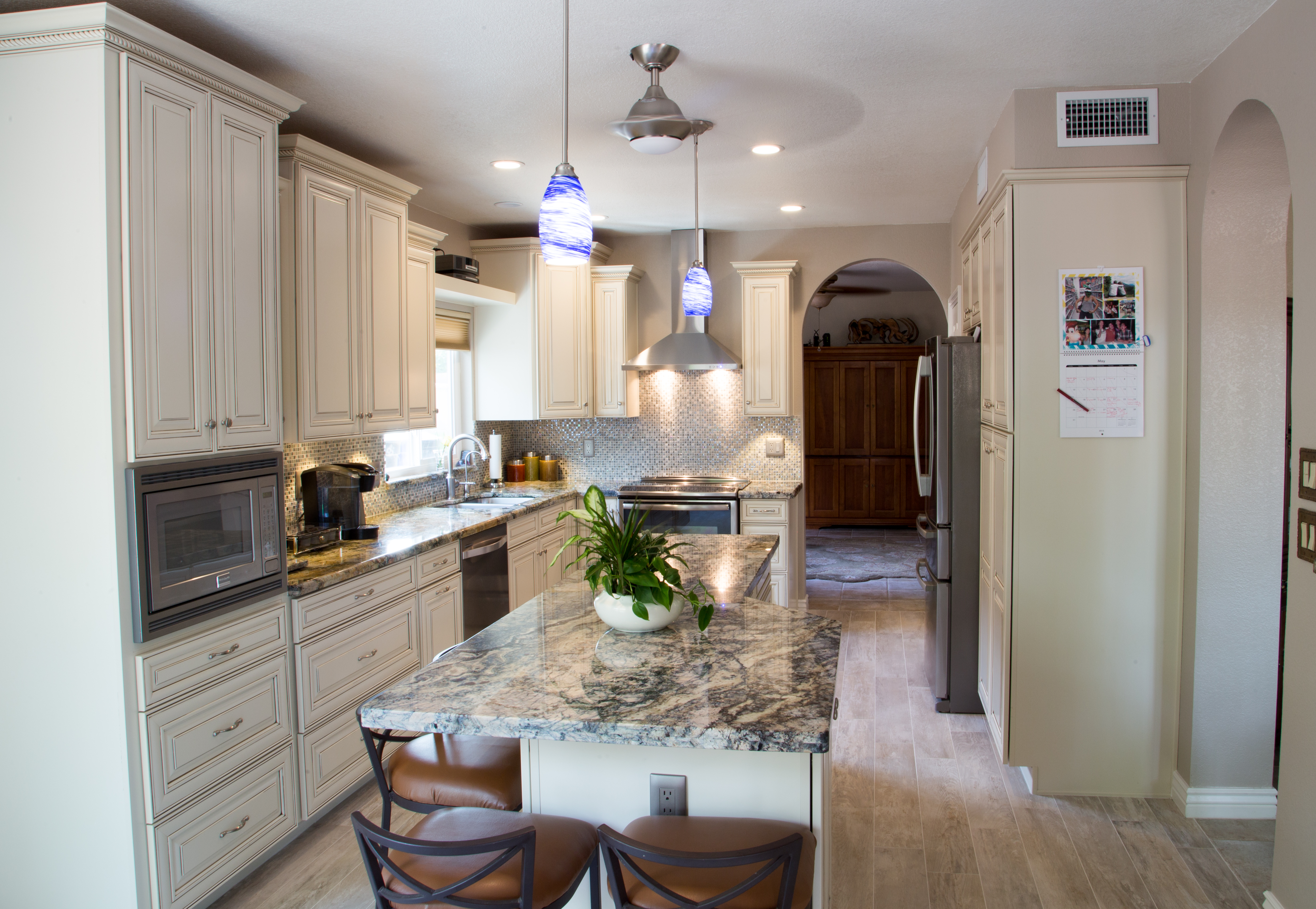 The Sierra Vista cabinetry with a painted Hazelnut finish from Timberlake Cabinetry perfectly compliments the gorgeous granite countertops and stainless steel fixtures in this newly remodeled kitchen. [TWD Project Location: Tempe, AZ]