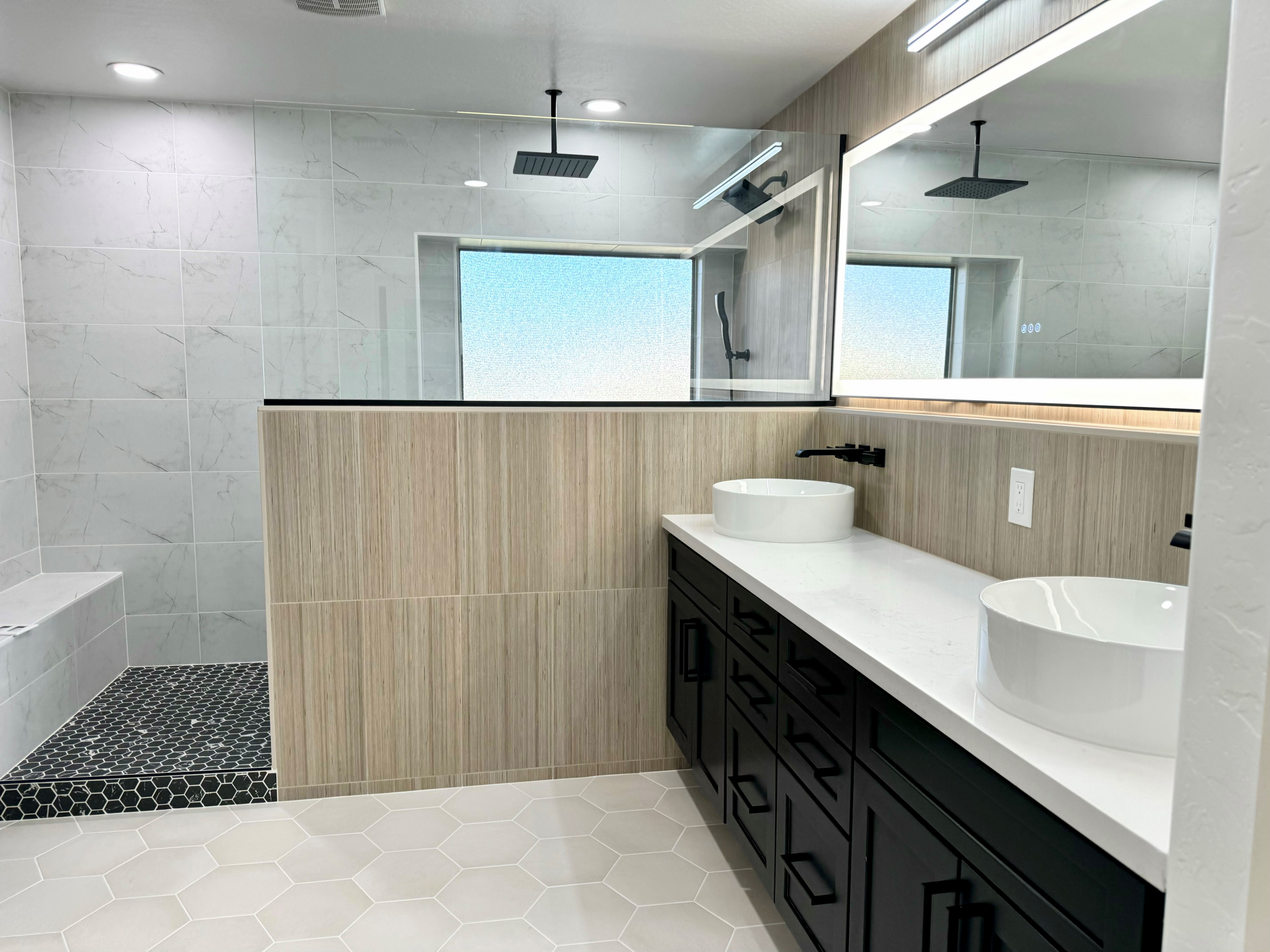 This Master Bathroom renovation turned an ordinary bath into a fabulous spa-like retreat that the homeowners are absolutely loving. The natural light from the window and LED backlit mirrors really brighten up the space, while the mix of tile textures and patterns create a cohesive natural feel. [TWD Project Location: Surprise, AZ]