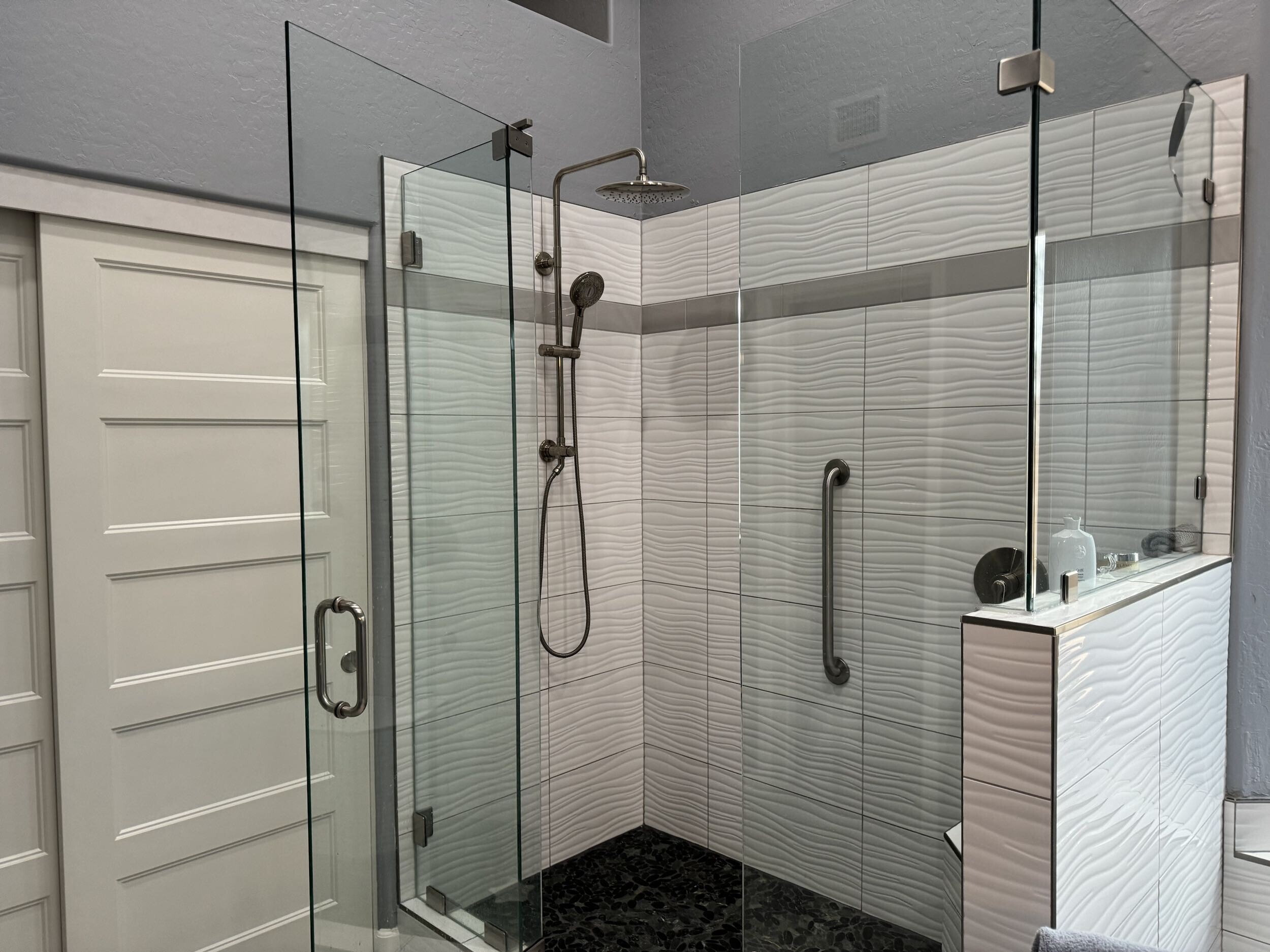 This over-sized walk-in shower with contemporary ripple glossy 3-D tile gives this Master Bathroom remodel a fresh new look. [TWD Project Location: Scottsdale, AZ]