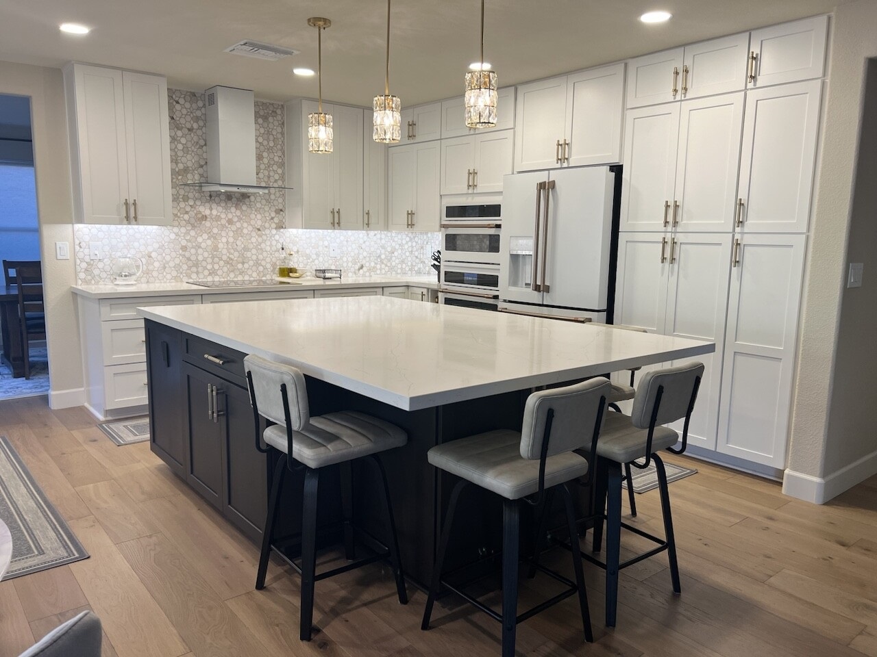 When a fantastic design and stunning material choices come to life, it produces a magazine worthy kitchen in this instance. This glamorous style features Waypoint Living Spaces cabinetry, polished quartz countertops, marble tile, gold fixtures and hardware, as well as new engineered hardwood flooring to perfectly complete the look. [TWD Project Location: Phoenix, AZ]