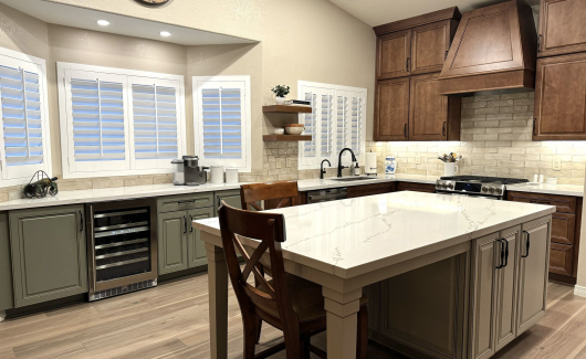 Tri-color cabinetry in this farmhouse style kitchen remodel. Wellborn Cabinet Select series cabinetry with a Concord door style used in the kitchen. The island was done in Gray Mist, while the perimeter cabinets are in Carmel. The built-in bar area however is Olive color with a Monteray door style.  [TWD Project Location: Phoenix, AZ]