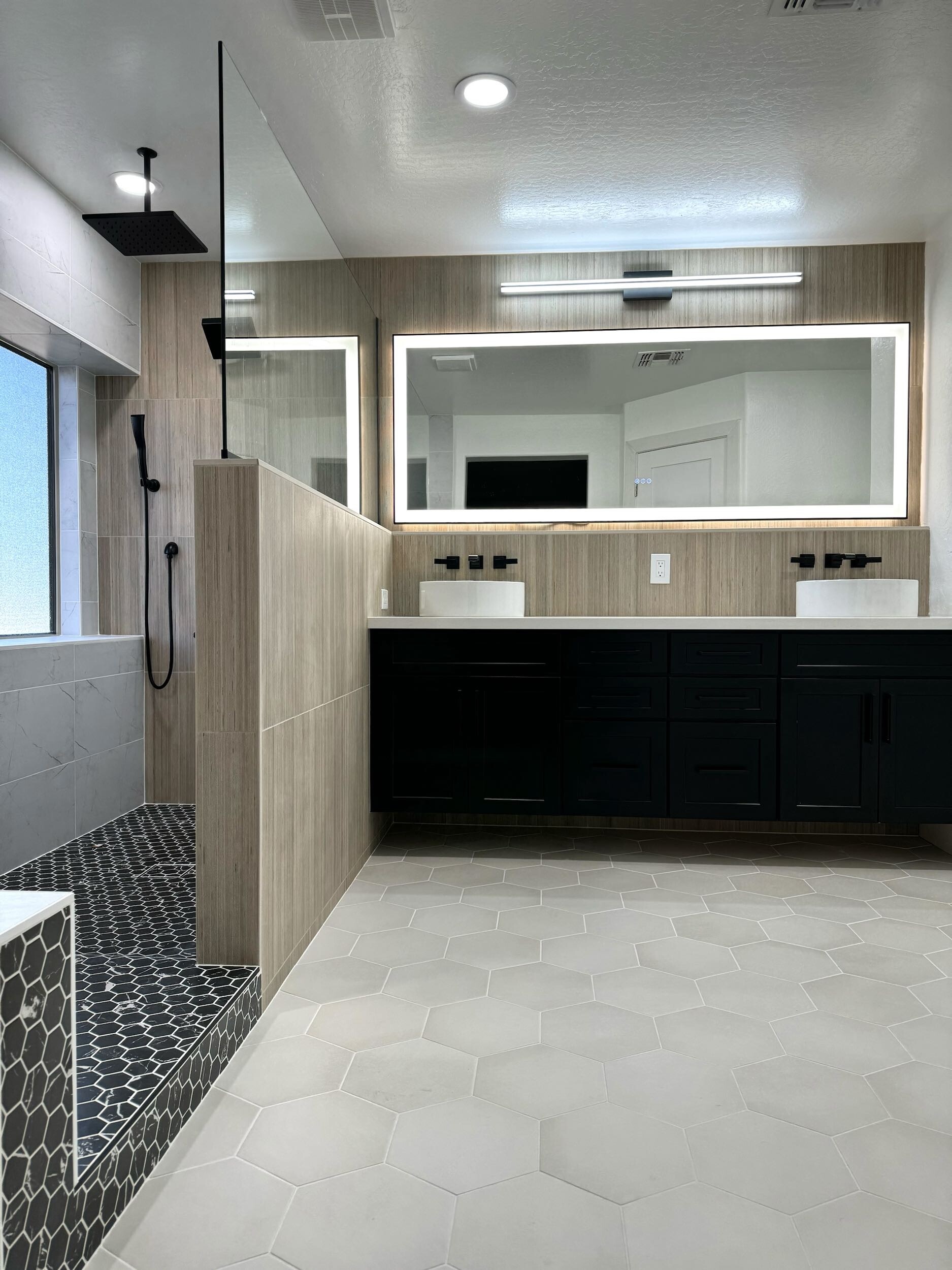 This Master Bathroom renovation turned an ordinary bath into a fabulous spa-like retreat that the homeowners are absolutely loving. The natural light from the window and LED backlit mirrors really brighten up the space, while the mix of tile textures and patterns create a cohesive natural feel. [TWD Project Location: Surprise, AZ]