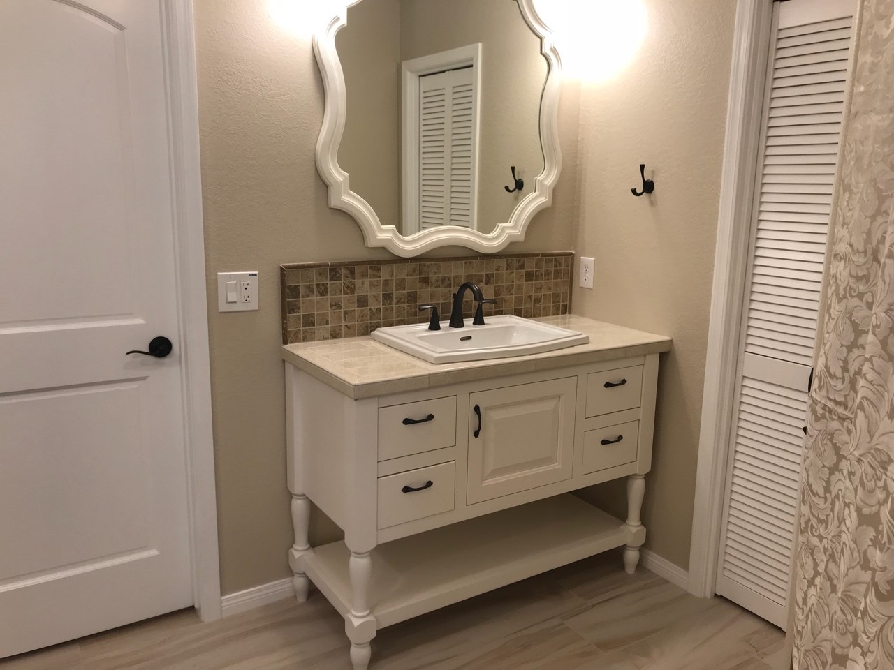 Master Bathroom Room Addition of 44 SF. Shabby chic design with furniture-like custom vanity from Wellborn, drop in sink, oil rubbed bronze hardware, mix of ceramic, travertine and porcelain mosaic tile, as well as decorative grab bars that all come together for a beautifully finished space.  [TWD Project Location: Sun City, AZ]