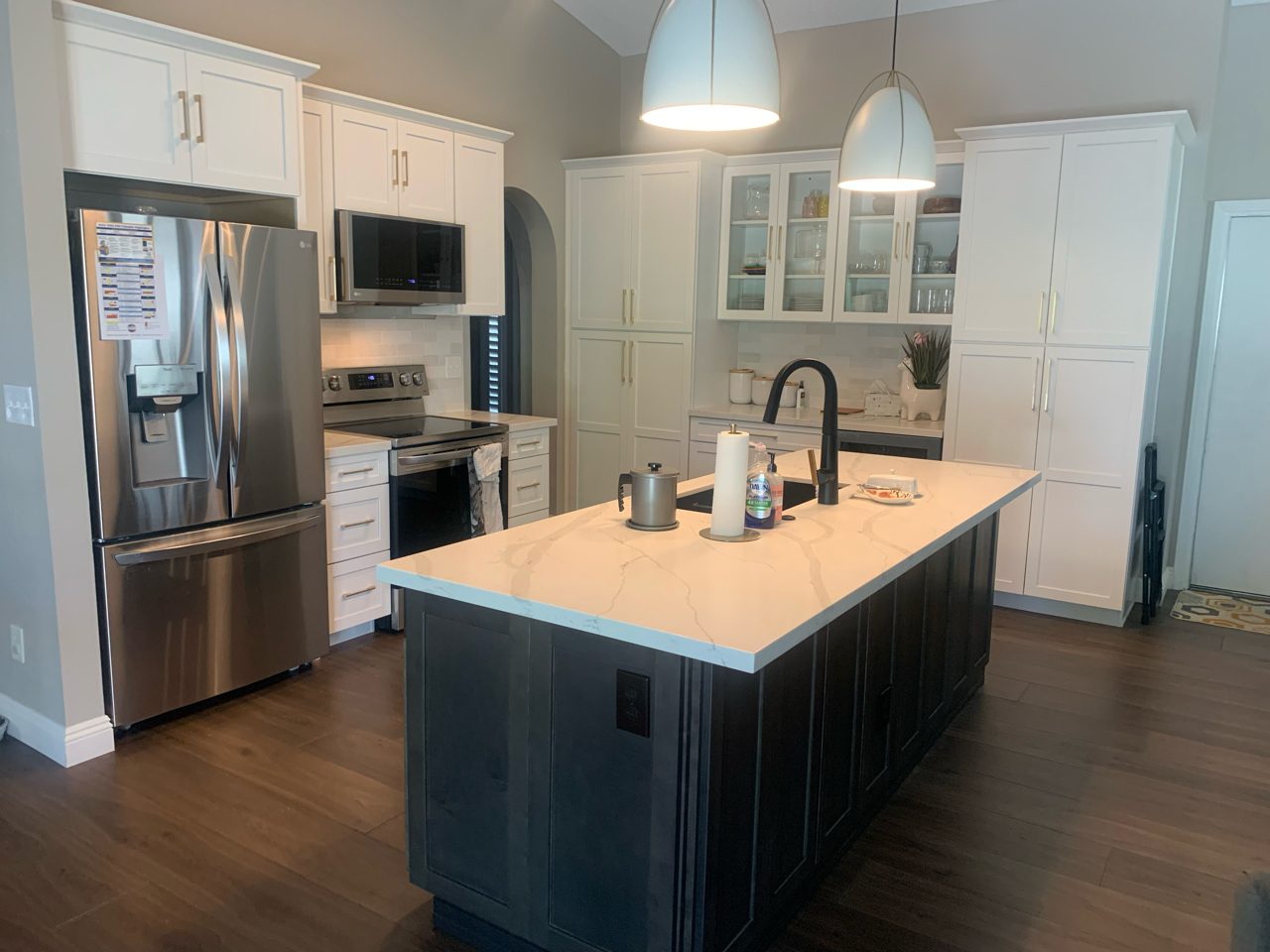 Two-tone cabinetry remains a common request. This recent kitchen remodel is no exception. Featuring Waypoint cabinetry in Maple Linen around the perimeter and Slate on the island, Calacatta Classic quartz countertops, and Chloe White tile backsplash. [TWD Project Location: Phoenix, AZ]