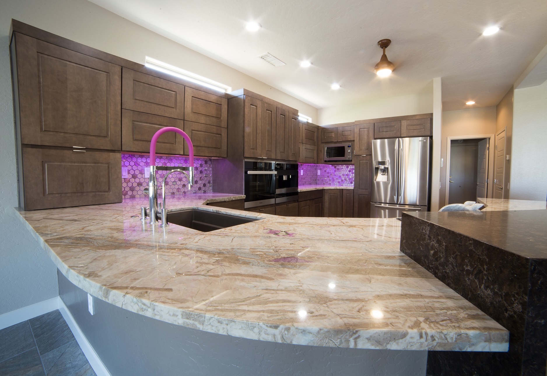 The detail and creative thought that went into making this full home remodel unique was an incredible experience. From the waterfall edge countertop to the hot pink kitchen faucet and Glitz Love glass mosaic, this truly was a custom design created around the customers favorite colors and materials. [TWD Project Location: Surprise, AZ]