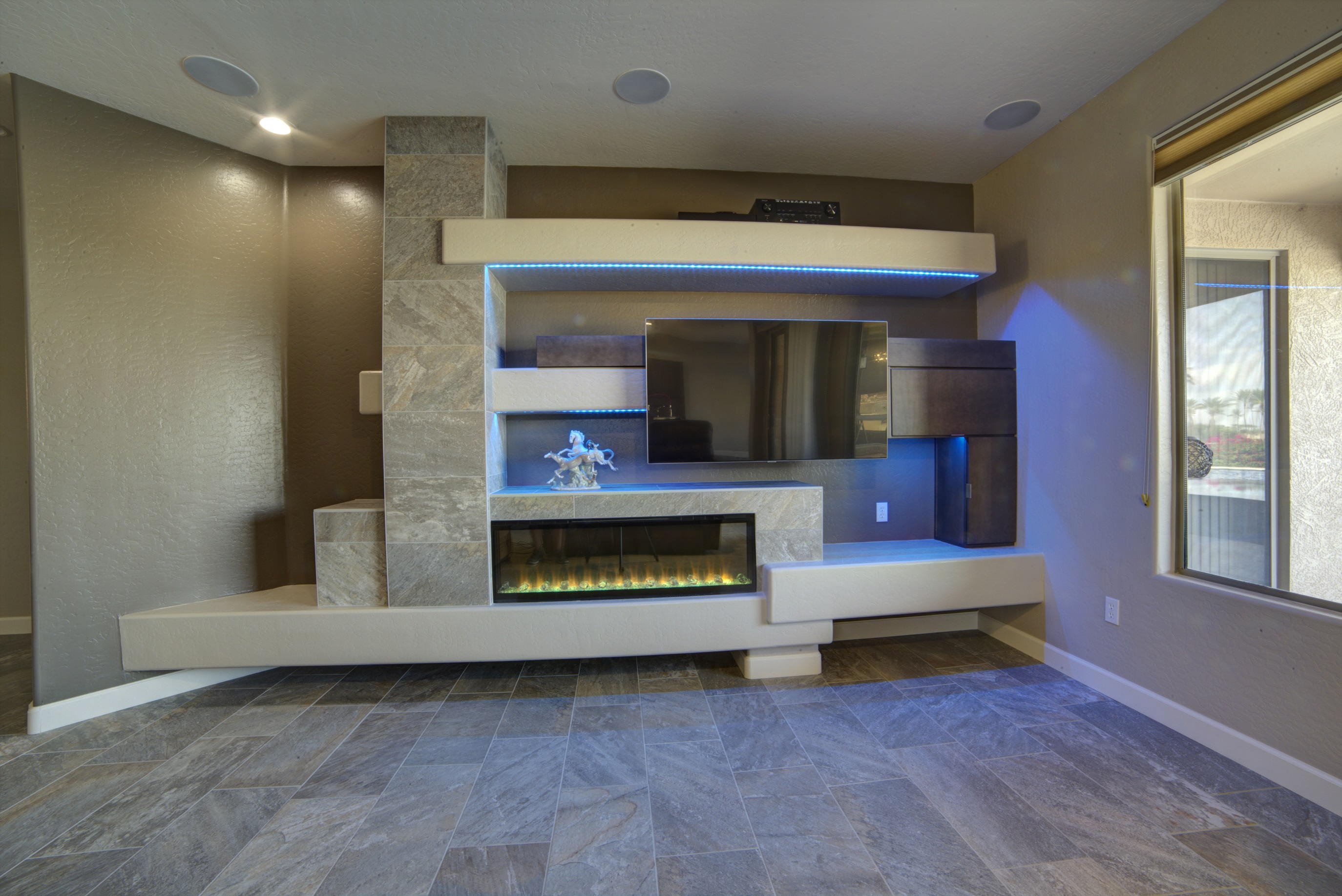 Precious Stone Venetian Blend tile, Wellborn Cabinetry, floating shelves and LED multi-color strip lighting brought this custom media wall to life. [TWD Project Location: Surprise, AZ]