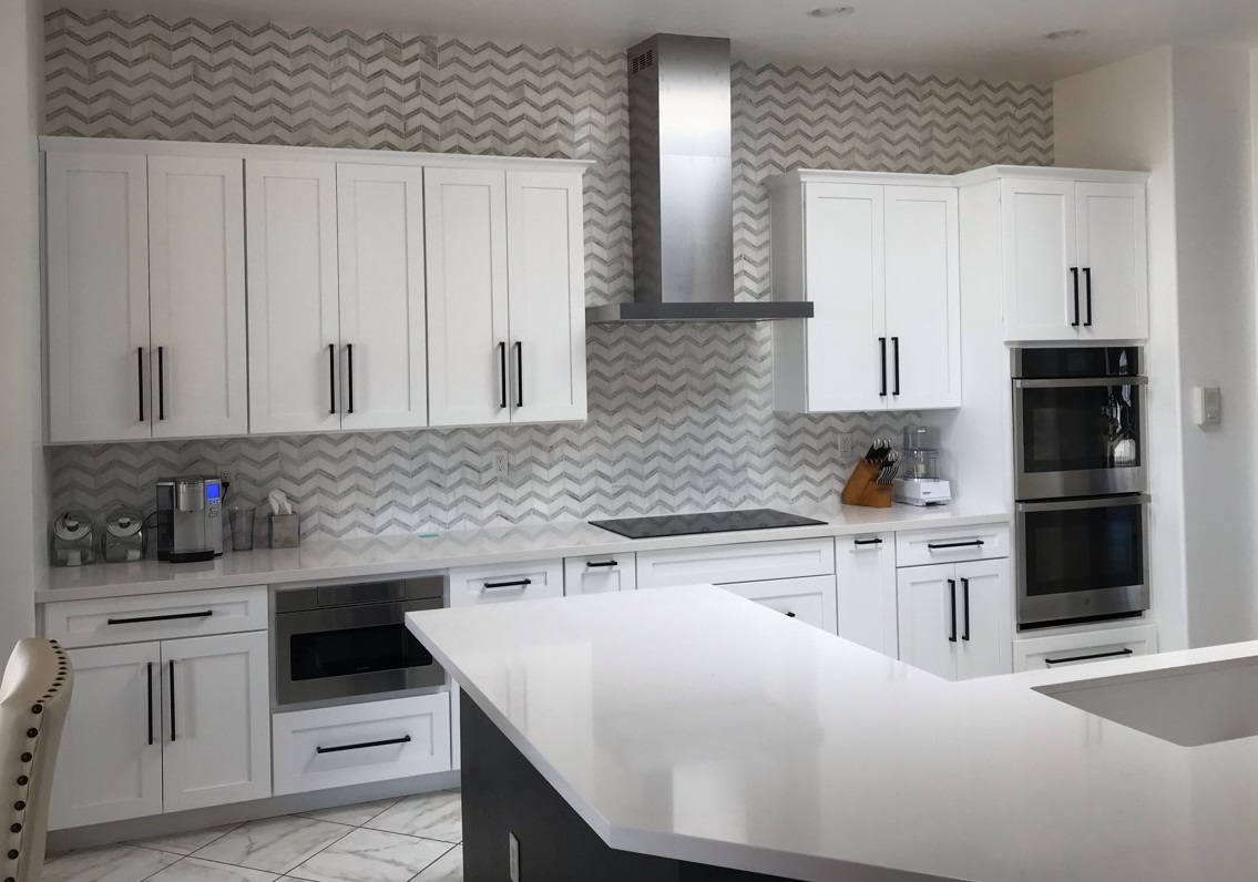 Kitchen remodel featuring Wellborn Cabinetry in Bright White against Bianco Chevron Marble tile backsplash and Silestone Quartz countertops. [TWD Project Location: Surprise, AZ]