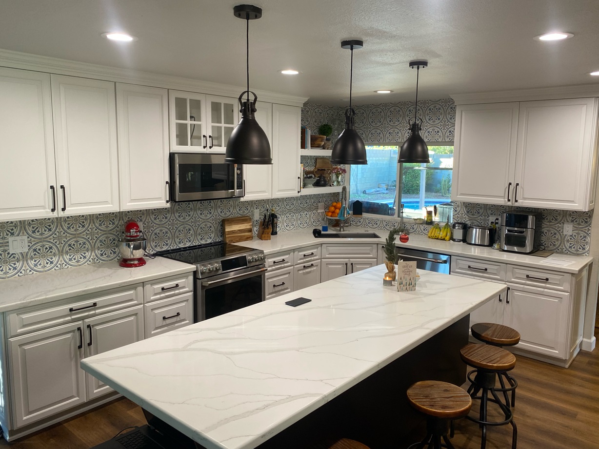 Two-tone cabinetry and decorative backsplash tile make this Kitchen remodel truly pop! The gorgeous Calacatta Crystal quartz countertops are the perfect pairing with a muted pattern that doesn't compete with the other design elements. [TWD Project Location: Phoenix, AZ]