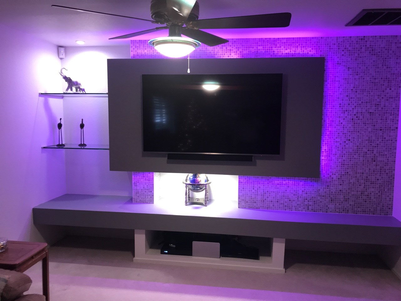 This 14'-2" x 8'-0" contemporary custom media wall is bursting with character. The multi-dimensional design with multi-colored remote operated LED wall lighting, glass mosaic tile, glass shelving and electrical upgrades create a great place for friends and family to gather. [TWD Project Location: Scottsdale, AZ]