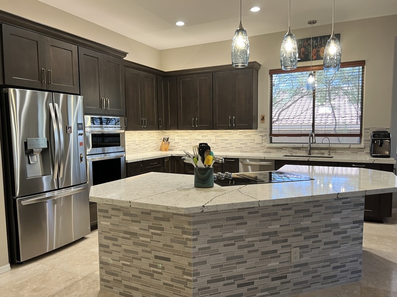 This luxury kitchen remodel features Alder Dusk cabinetry from OakCraft Cabinet Timeliness line. The spacious island countertop is definitely the focal point of the space though. [TWD Project Location: Scottsdale, AZ]