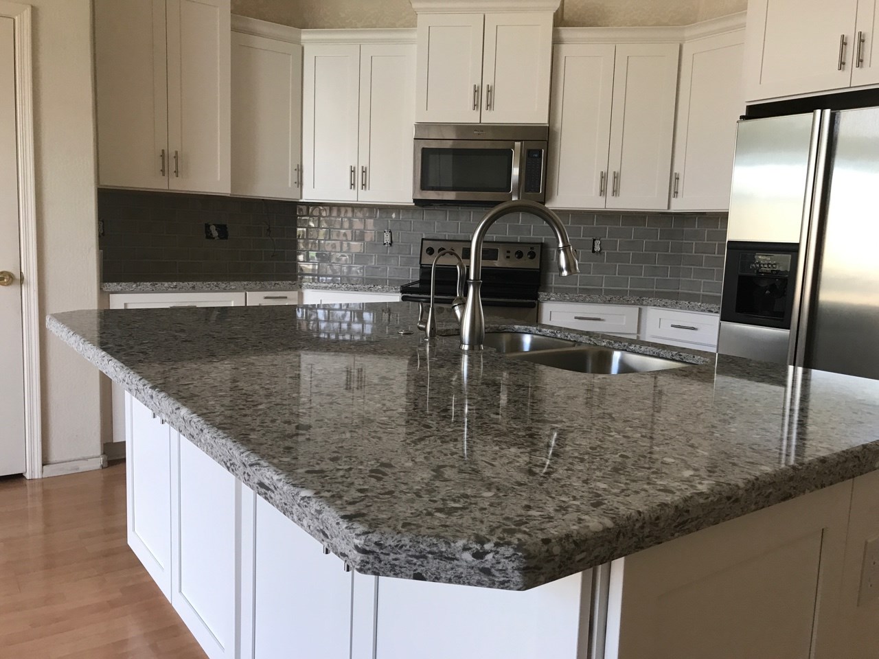 Wellborn Cabinetry topped with stunning quartz countertops and subway tile backsplash for a timeless gray and white scheme. [TWD Project Location: Phoenix, AZ]