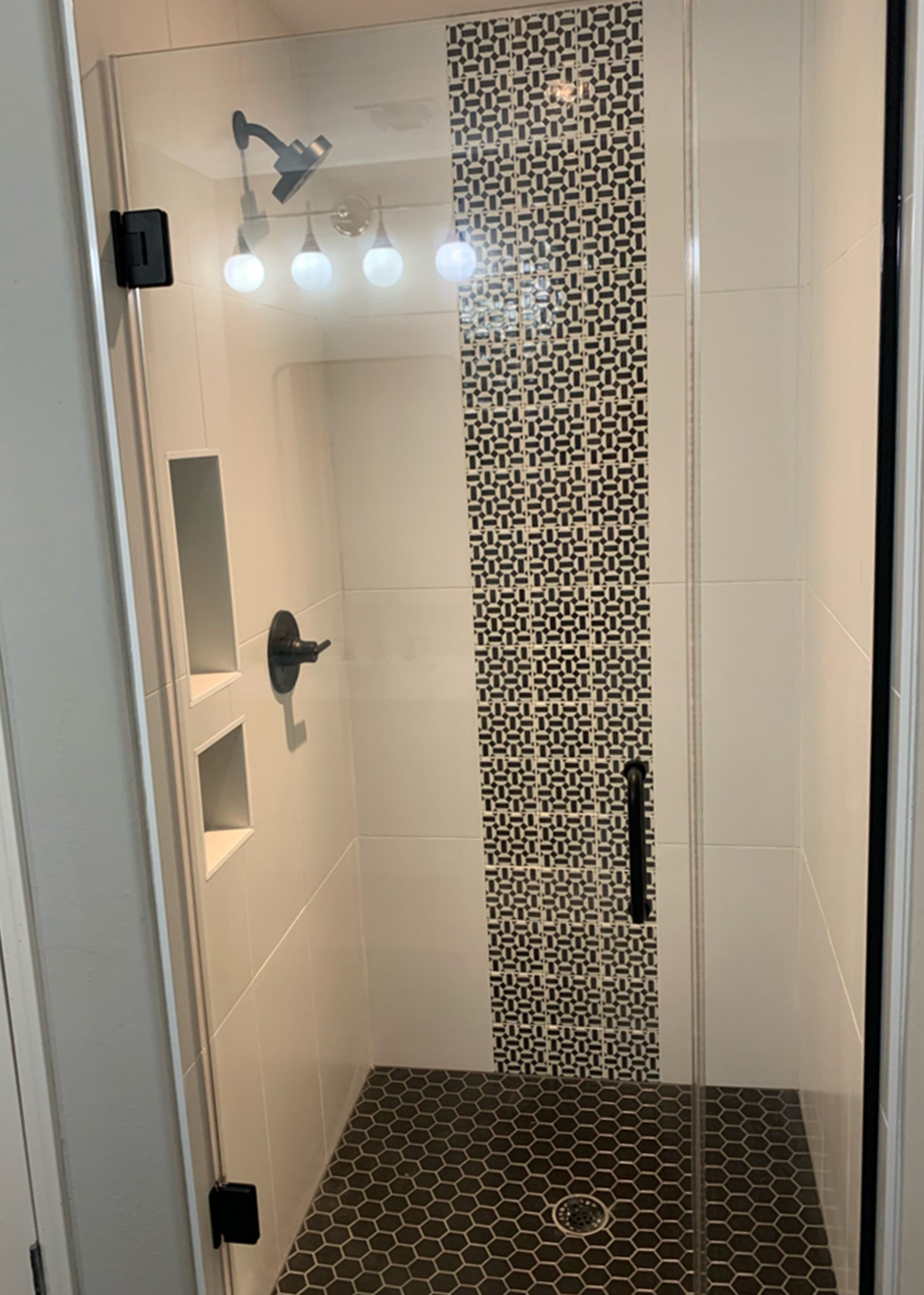 Gorgeous condo living downtown where TWD remodeled both bathrooms. The guest bathroom was done in a black and white palette with 12" x 24" polished white tile on the shower walls, a 5" x 5" decorative mosaic accent, 2" round mosaic tile on the shower floor and matte black Delta plumbing fixtures. [TWD Project Location: Phoenix, AZ]