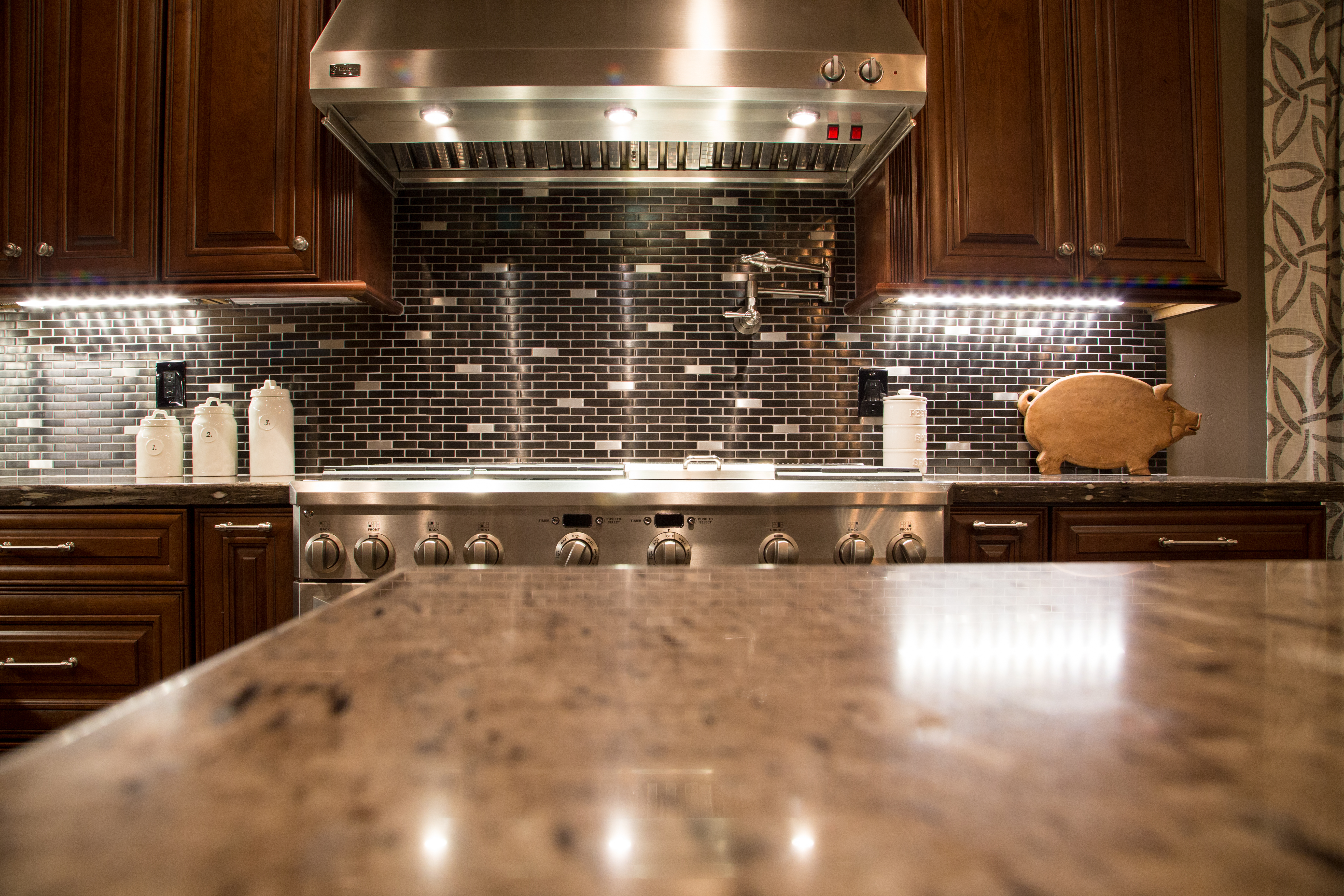 GE Monogram 36" Refrigerator and 36" Freezer, 48" Pro Wall Hood with a 48" range with griddle, an over-sized island with ample prep space topped with new Bordeaux granite countertops and a black metal brick backsplash are just a few of this remodeled Kitchen's features that will attract your attention. [TWD Project Location: Surprise, AZ]