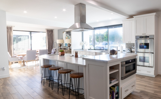 This full home renovation went from a complete gut to completely gorgeous. The kitchen features Wellborn Premier series cabinetry in a Glacier White finish with quartz countertop, gray ceramic tile backsplash, (2) kitchen sinks, stainless steel appliances and hood. [TWD Project Location: Litchfield Park, AZ]