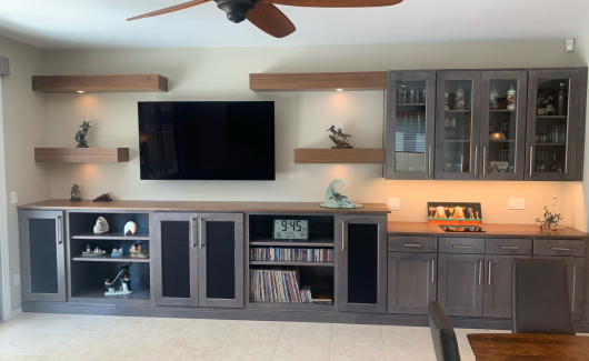 This expansive custom media wall features plenty of storage space and cabinetry making it ideal for a Great Room or to utilize as a beverage center as well. The Maple Smoke colored cabinetry and walnut colored shelving are the perfect color combination. [TWD Project Location: Anthem, AZ]