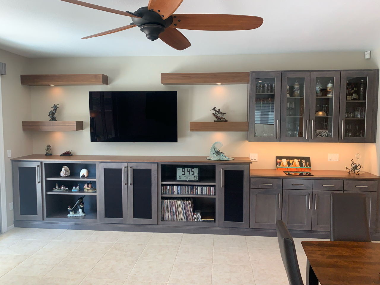 This expansive custom media wall features plenty of storage space and cabinetry making it ideal for a Great Room or to utilize as a beverage center as well. The Maple Smoke colored cabinetry and walnut colored shelving are the perfect color combination. [TWD Project Location: Anthem, AZ]