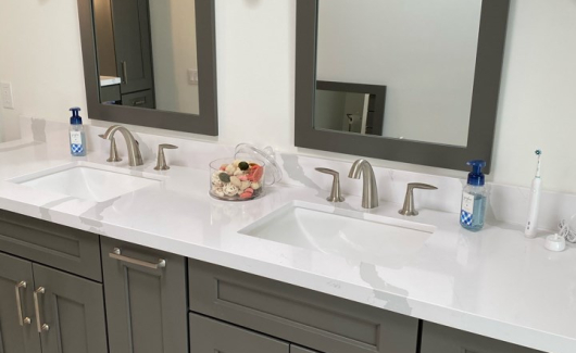 This master suite bathroom design features his and her sinks and a separate dedicated makeup area with an abundance cabinet storage. The newly designed bathroom provides dual entrances to the glamorous new walk-in closet. [TWD Project Location: Litchfield Park, AZ]