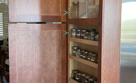 Maximize your space with a new spice cabinet in your kitchen design. Gorgeous cherry cabinet kitchen showing Wellborn Cabinets in Millbrook door style. [TWD Project Location: Scottsdale, AZ]